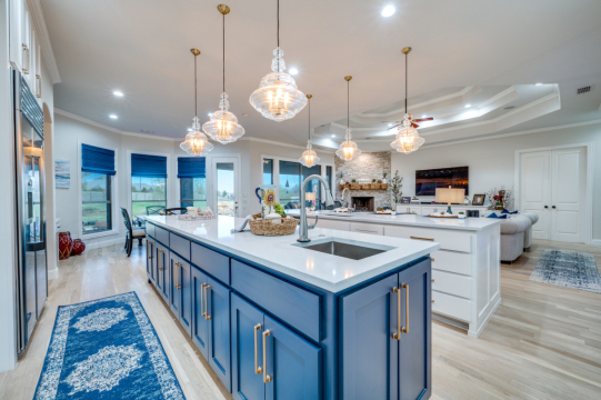 kitchen island with white countertop and blue cabinets with gold hardware